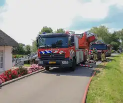 Brandweer blust brand in rietenkap van woning