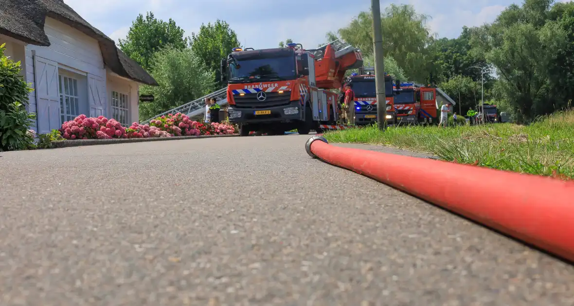 Brandweer blust brand in rietenkap van woning - Foto 1