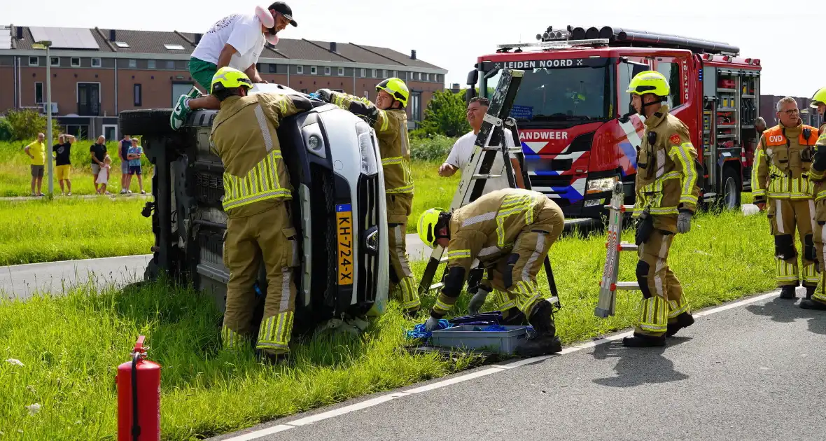 Oudere man belandt met auto op de zij - Foto 1