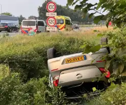 Auto belandt op zijn kop in sloot naast snelweg