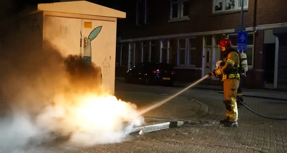 Brandweer blust brand naast afvalcontainer