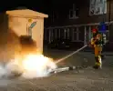 Brandweer blust brand naast afvalcontainer
