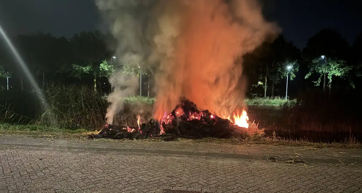 Stapel hooi vliegt in brand