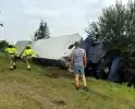 Vrachtwagen belandt in sloot naast snelweg, chauffeur ongedeerd