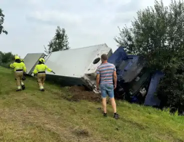 Vrachtwagen belandt in sloot naast snelweg, chauffeur ongedeerd