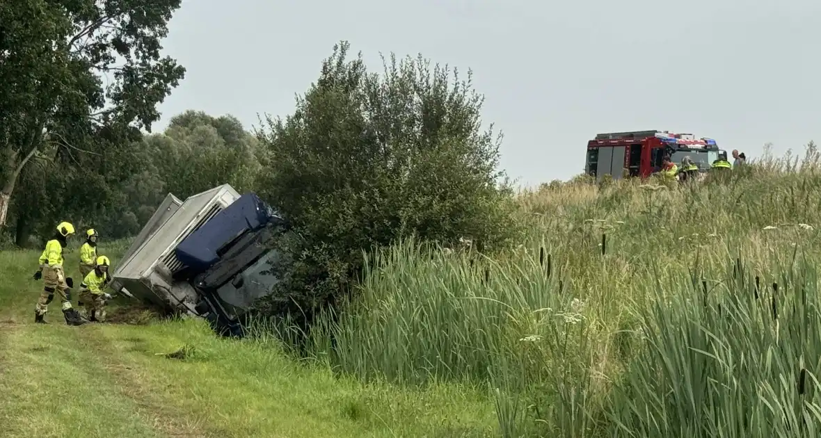 Vrachtwagen belandt in sloot naast snelweg, chauffeur ongedeerd - Foto 1