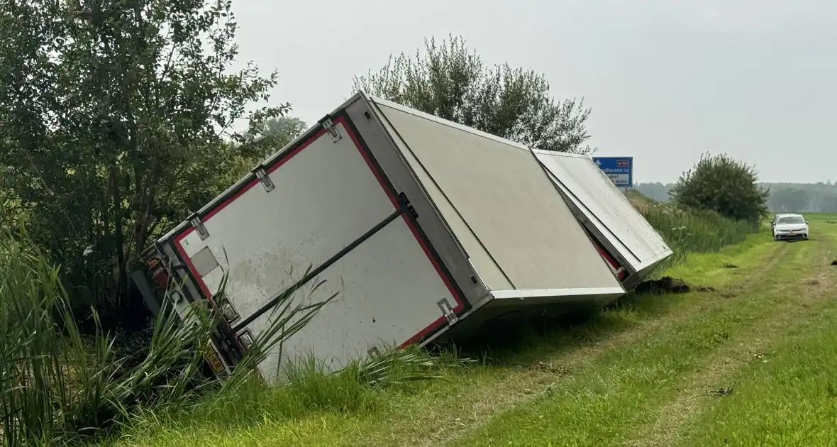 Vrachtwagen belandt in sloot naast snelweg, chauffeur ongedeerd - Foto 3