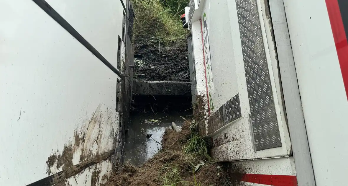 Vrachtwagen belandt in sloot naast snelweg, chauffeur ongedeerd - Foto 8