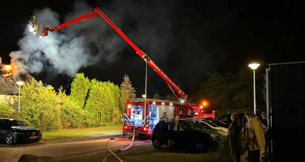 Vlammen slaan uit rietendak van woning - Foto 4