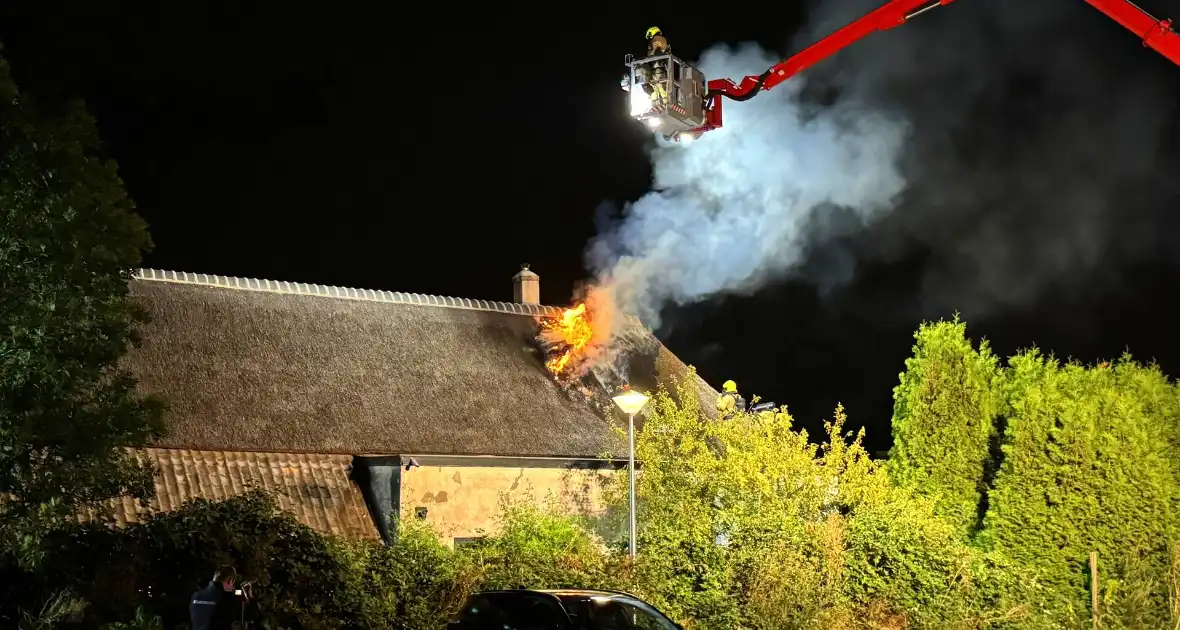 Vlammen slaan uit rietendak van woning - Foto 5