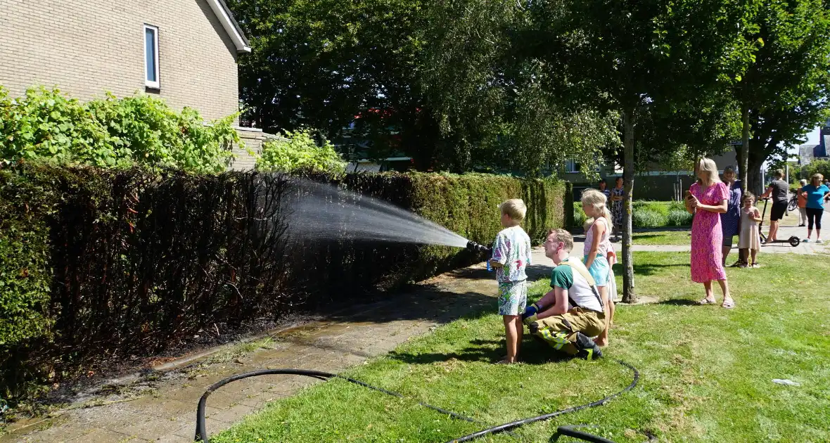 Kinderen blussen met brandweer brandende coniferenhaag - Foto 3