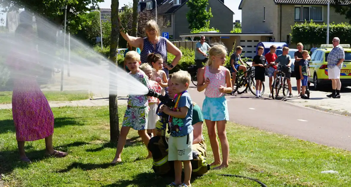 Kinderen blussen met brandweer brandende coniferenhaag - Foto 4