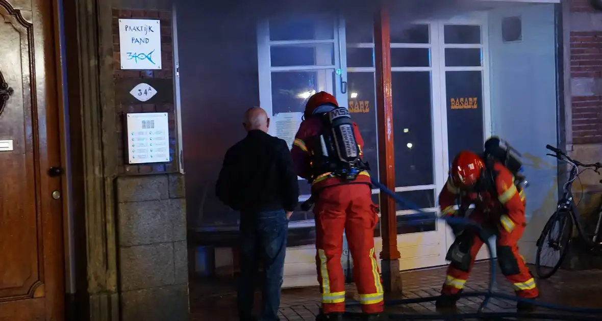 Brandweer blust brandende winkel - Foto 3