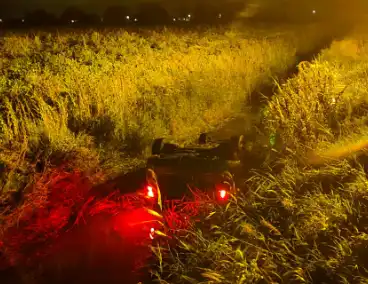 Auto vliegt uit de bocht en belandt ondersteboven in sloot