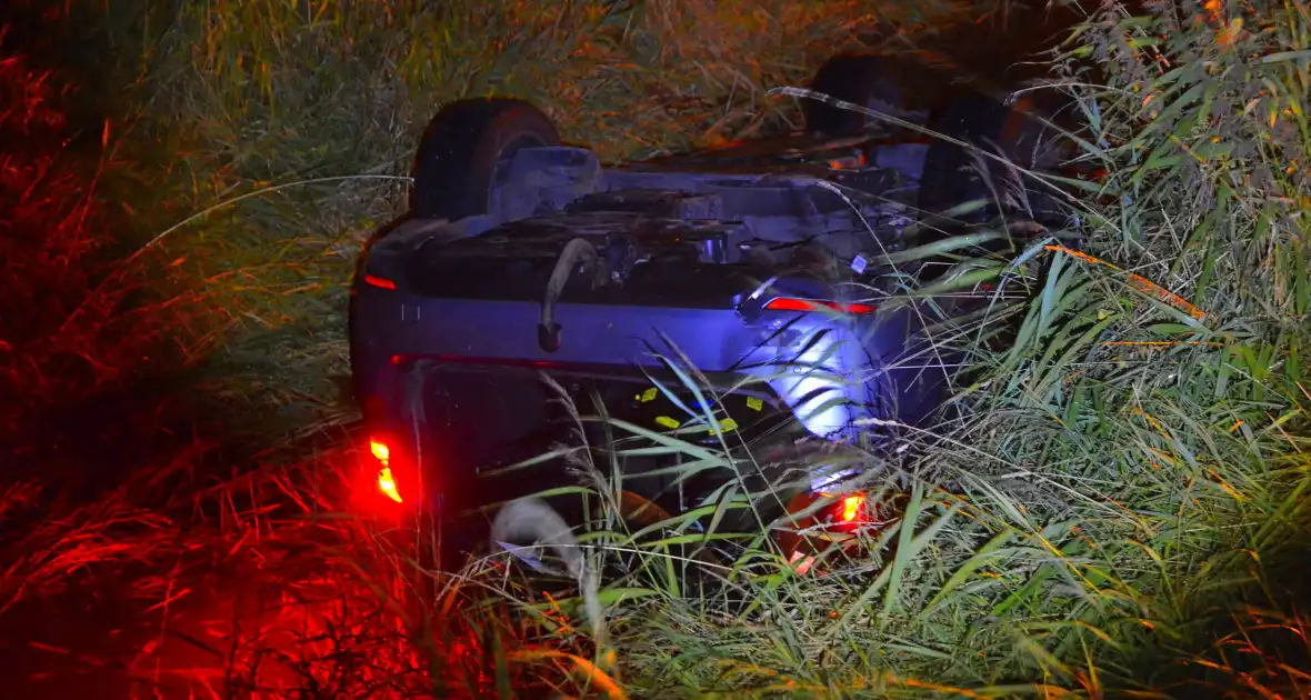 Auto vliegt uit de bocht en belandt ondersteboven in sloot - Foto 1