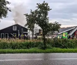 Brandweer blust brandende tussenmuur bij kaasboerderij