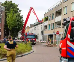 Veel rookontwikkeling bij brand op dak bij portiekwoning