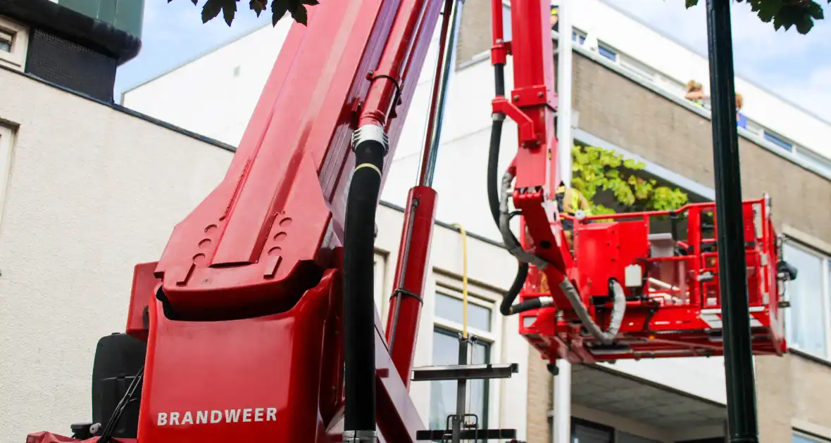 Veel rookontwikkeling bij brand op dak bij portiekwoning - Foto 1