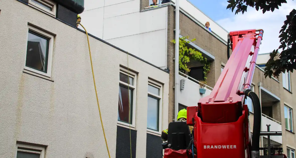 Veel rookontwikkeling bij brand op dak bij portiekwoning - Foto 2