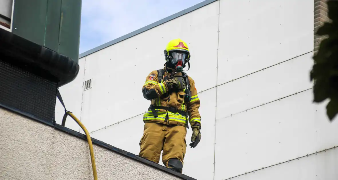 Veel rookontwikkeling bij brand op dak bij portiekwoning - Foto 8