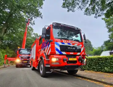 Brandweer verwijdert gevaarlijk hangende tak met hoogwerker