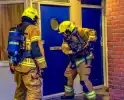 Brandalarm door visroken: brandweer ramt deur van buren in