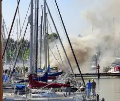 Veel rook in haven door brandend vaartuig