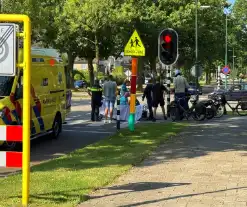 Ambulancemedewerkers behandelen gevallen snorfietser