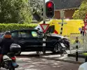 Twee voertuigen botsen op elkaar waarna een op een verkeerslicht klapt