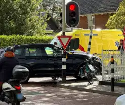 Twee voertuigen botsen op elkaar waarna een op een verkeerslicht klapt