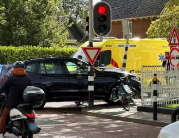 Twee voertuigen botsen op elkaar waarna een op een verkeerslicht klapt