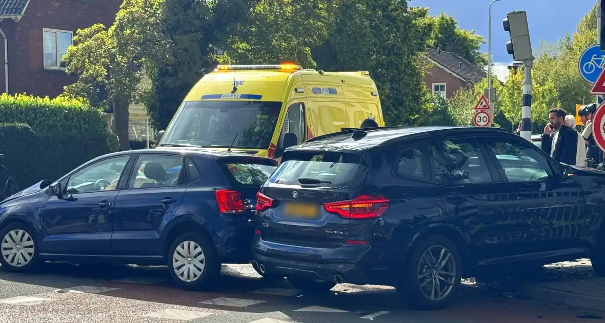 Twee voertuigen botsen op elkaar waarna een op een verkeerslicht klapt - Foto 3