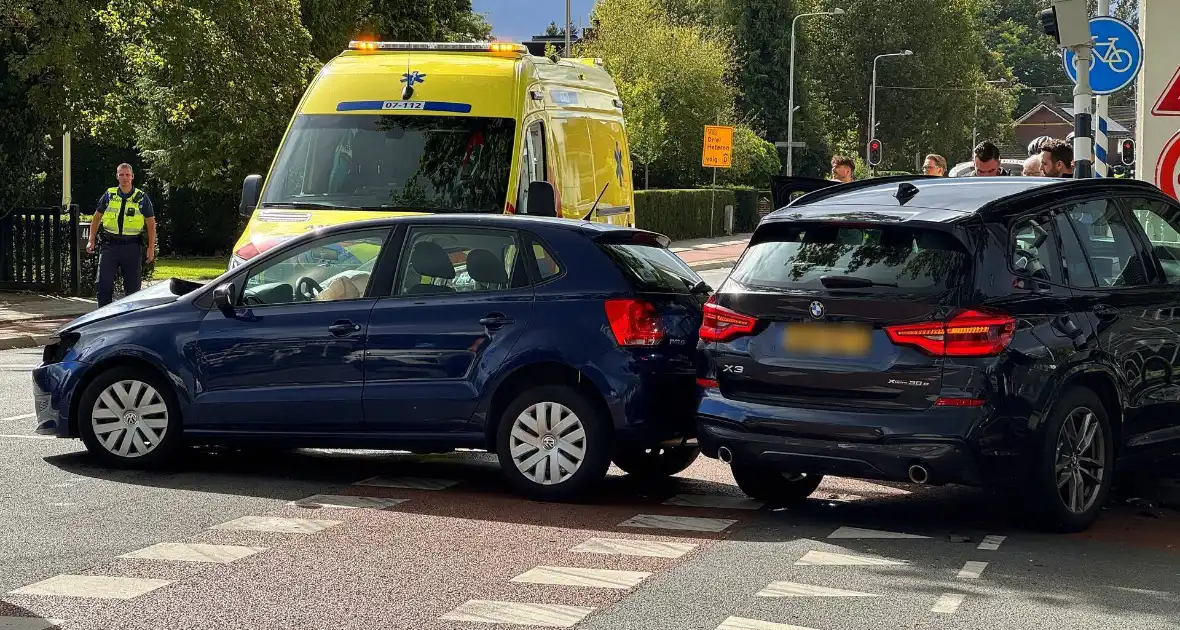 Twee voertuigen botsen op elkaar waarna een op een verkeerslicht klapt - Foto 4