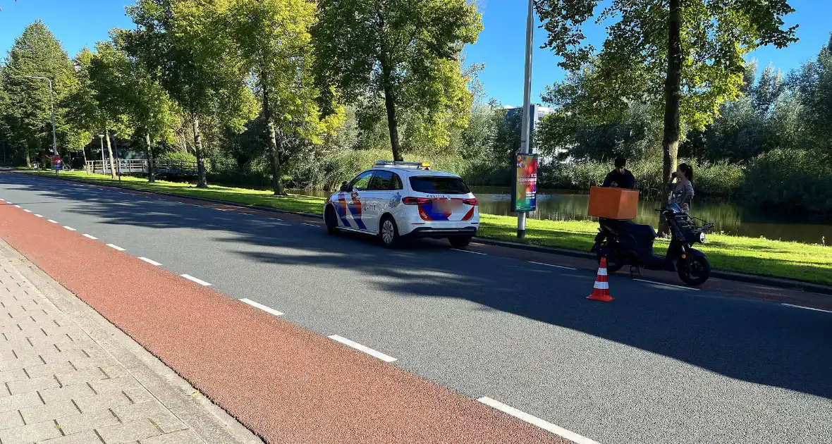 Bezorgscooter en fietser in botsing met elkaar