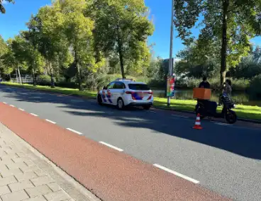 Bezorgscooter en fietser in botsing met elkaar