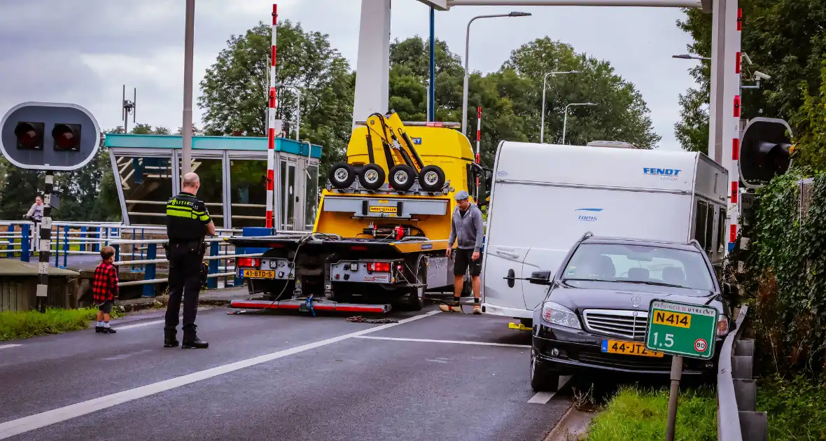 Auto met caravan belandt aan andere kant van weg - Foto 1