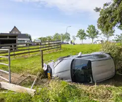 Omstanders halen automobilist uit te water geraakte auto