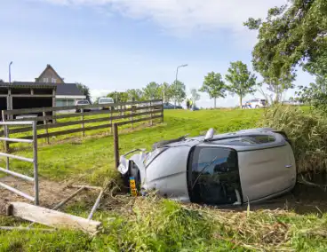 Omstanders halen automobilist uit te water geraakte auto