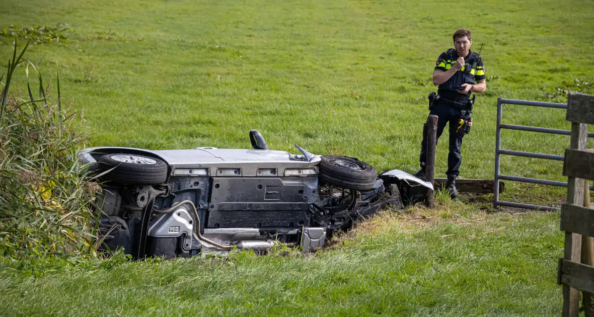 Omstanders halen automobilist uit te water geraakte auto - Foto 2