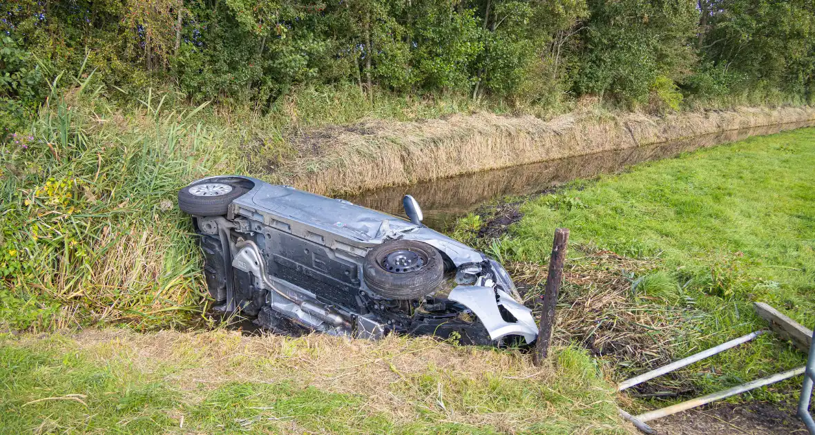 Omstanders halen automobilist uit te water geraakte auto - Foto 4