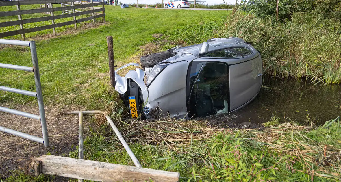 Omstanders halen automobilist uit te water geraakte auto - Foto 5