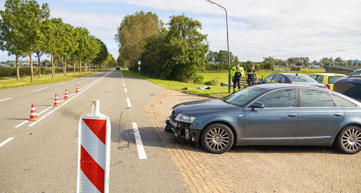 Omstanders halen automobilist uit te water geraakte auto - Foto 8