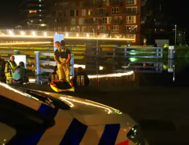 Persoon klimt op palen onder brug en word gebeten door politiehond