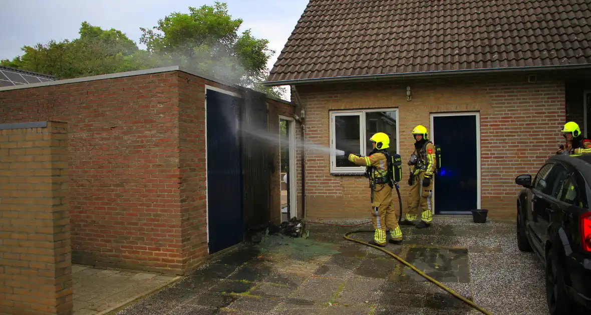 Brand in kliko slaat over op garagedeur