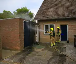 Brand in kliko slaat over op garagedeur