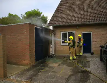 Brand in kliko slaat over op garagedeur