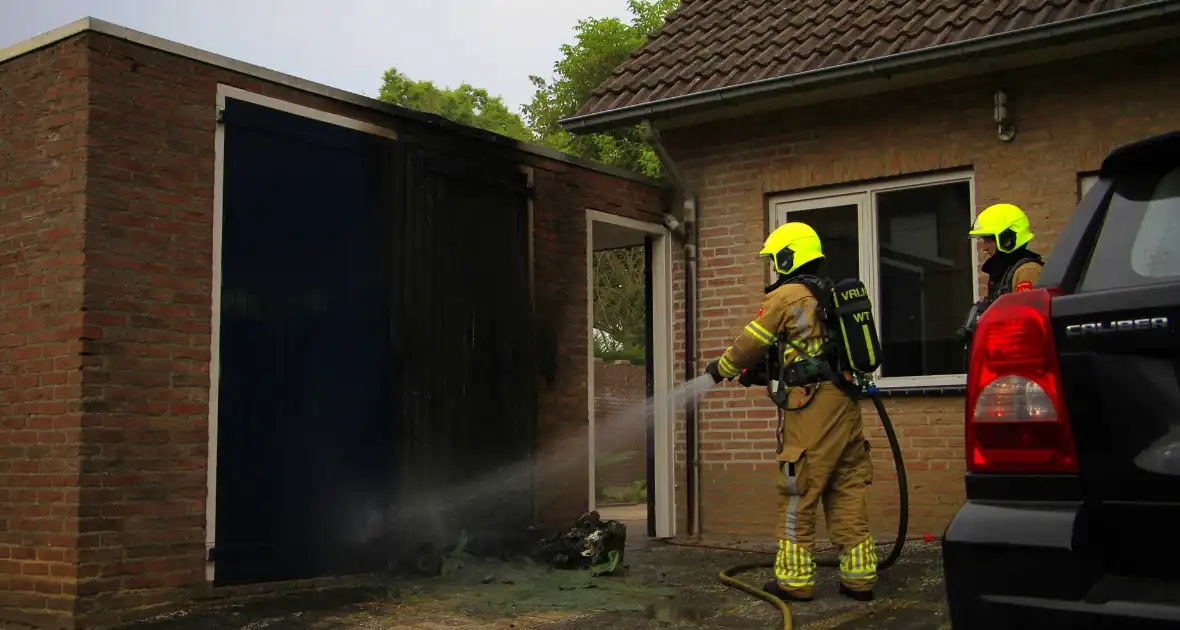 Brand in kliko slaat over op garagedeur - Foto 1