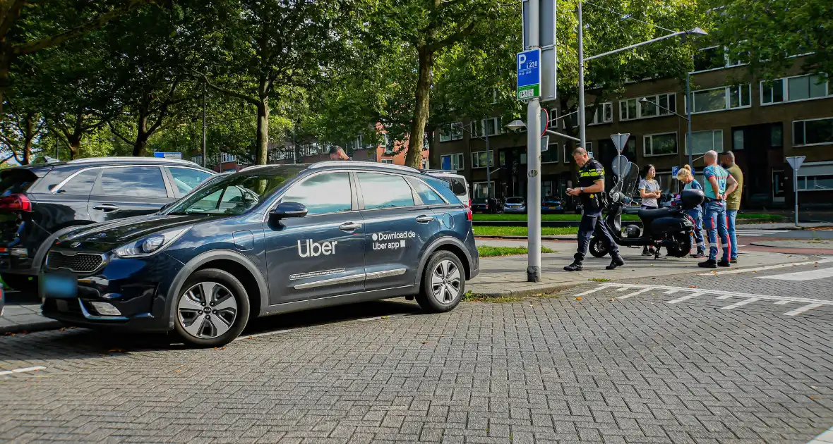 Taxichauffeur en scooterrijder in botsing