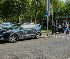 Taxichauffeur en scooterrijder in botsing