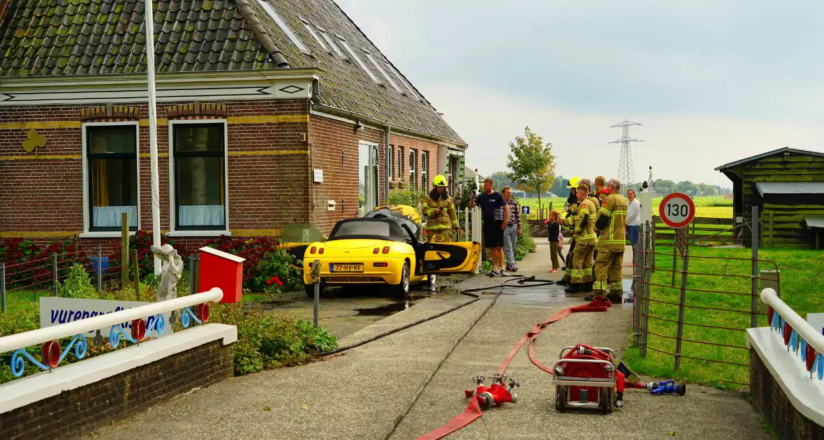 Personenwagen naast woning vliegt in brand - Foto 2